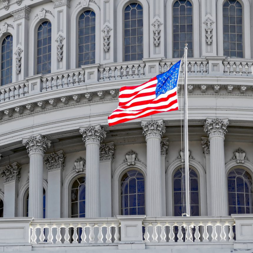 US flag flies at US Capitol building.
