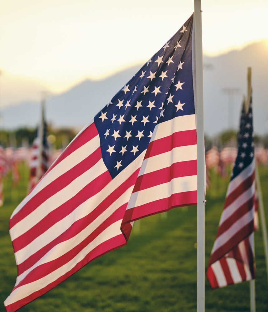 American flag waving in field.